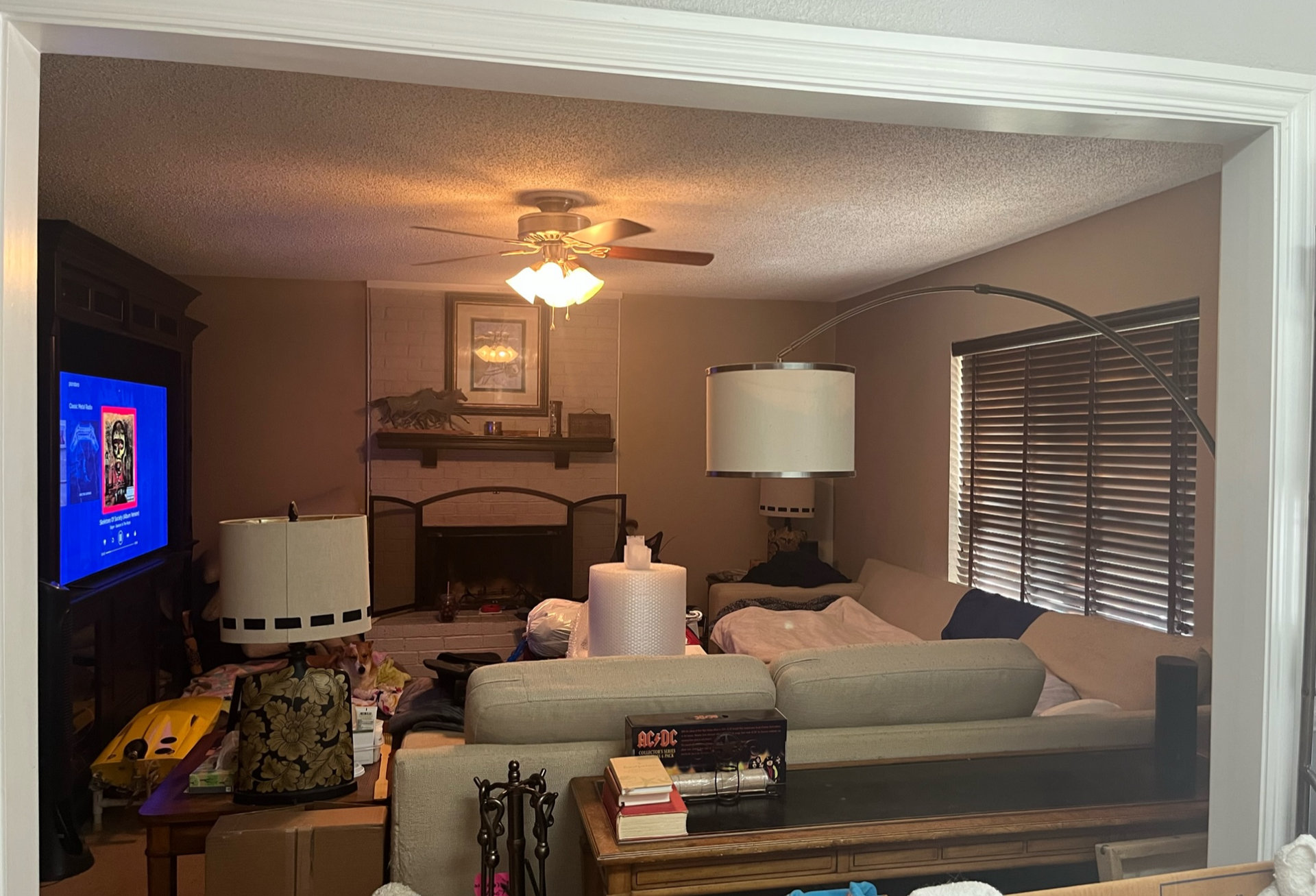A living room with a couch , fireplace and television.