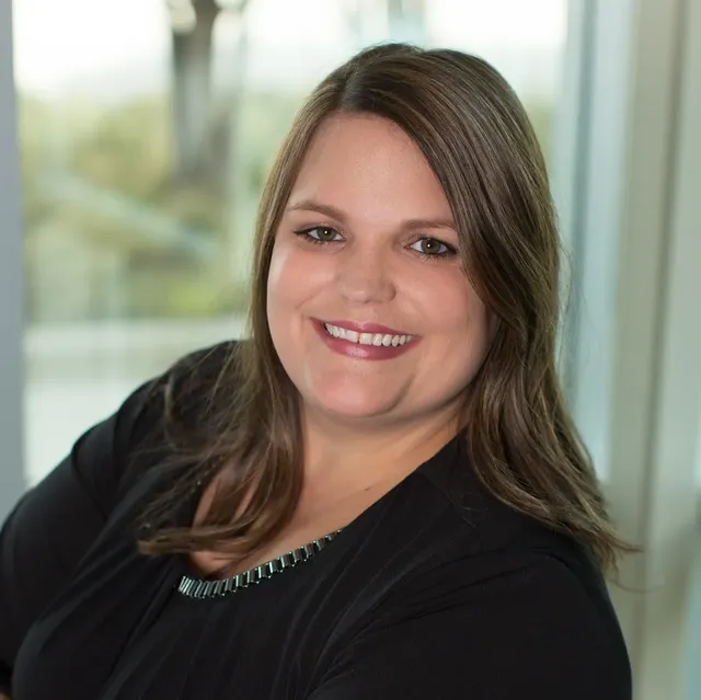 A woman in a black shirt is smiling for the camera