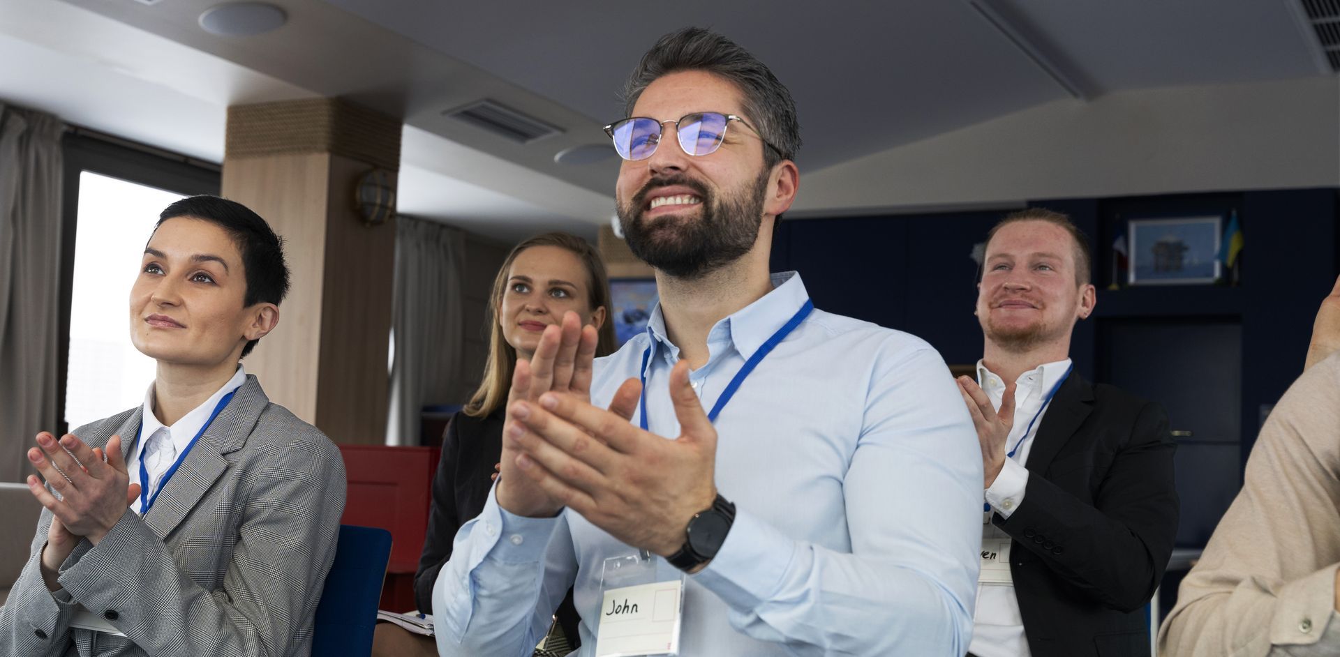 A group of people are clapping their hands in a room.