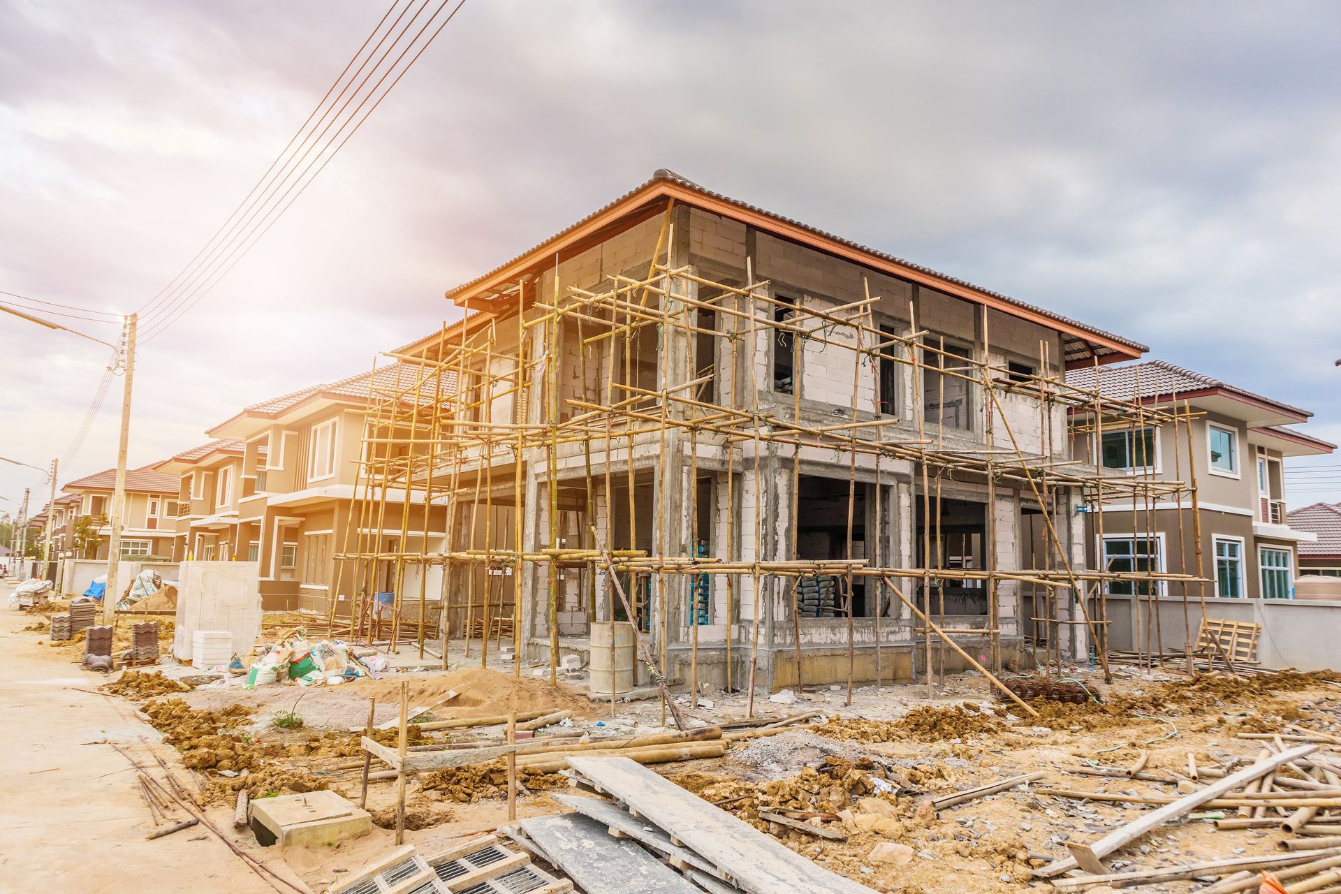 a house is being built in a residential area with scaffolding around it .