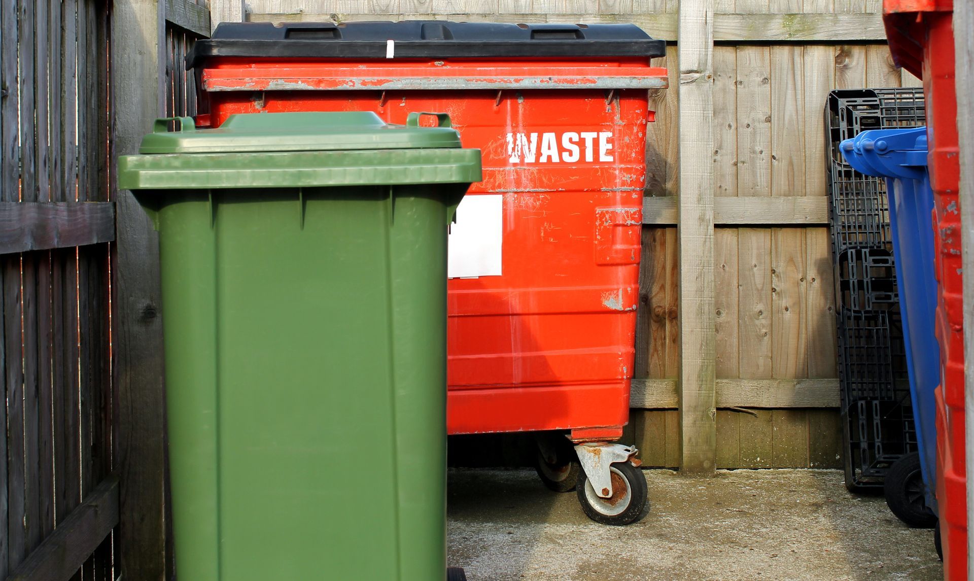 a red dumpster with the word waste on it