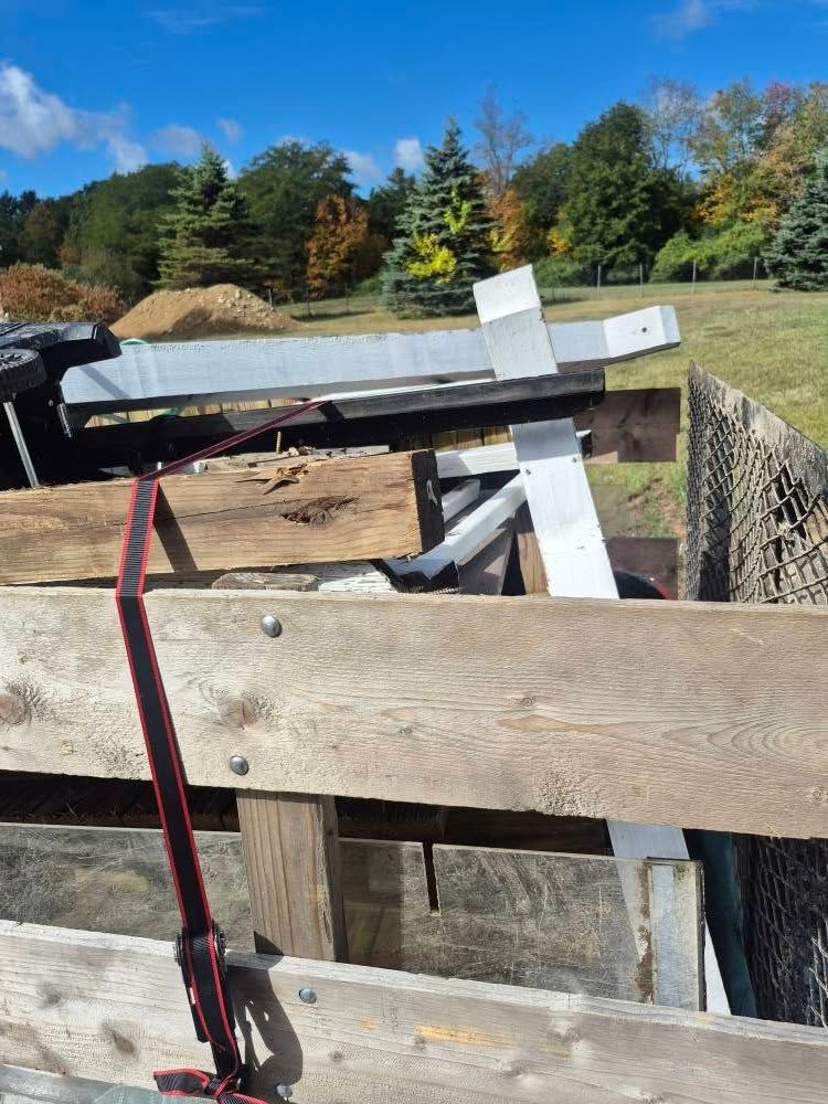 Wooden and metal construction materials in a truck bed on a sunny day.