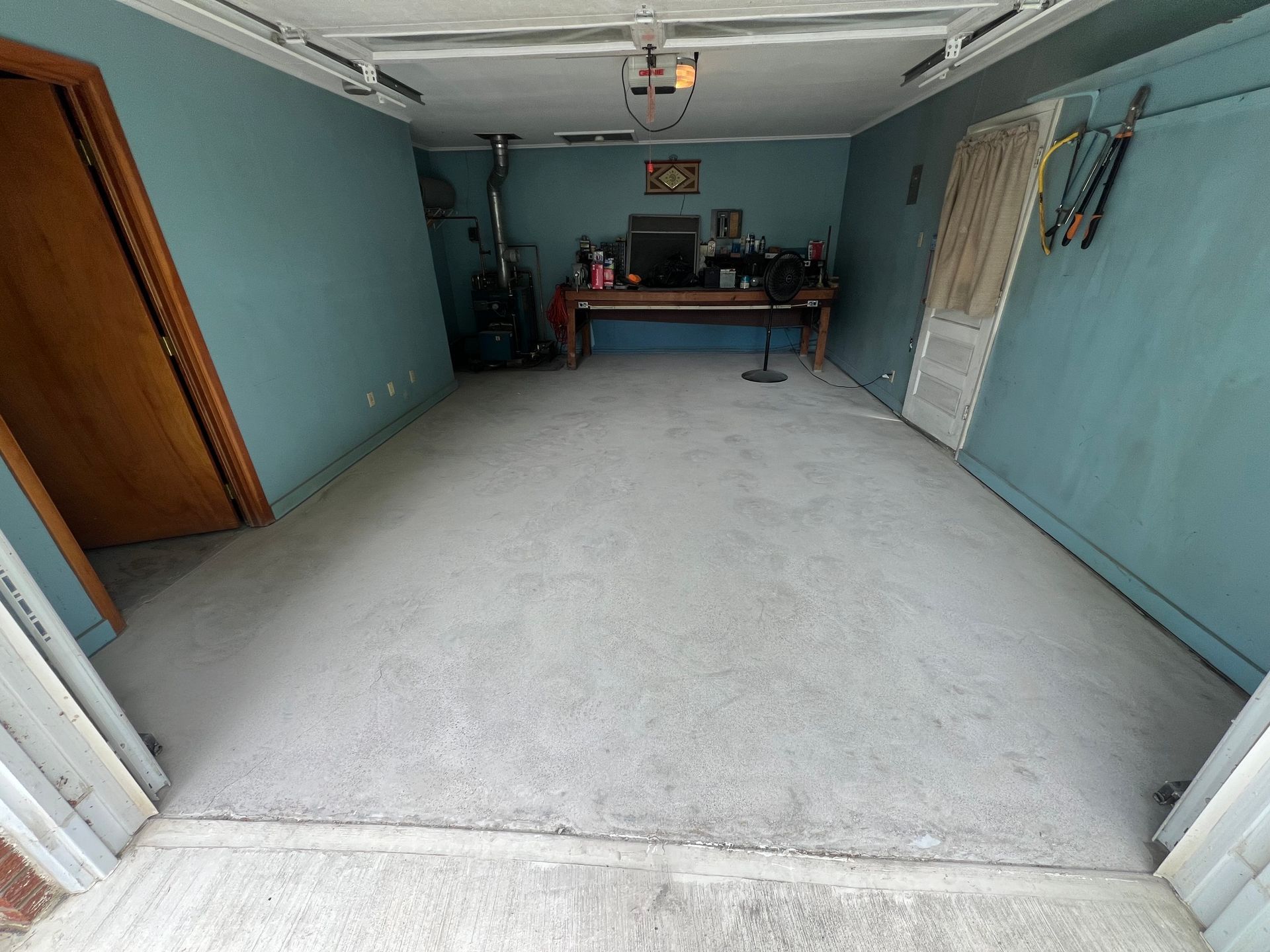 An empty garage with a desk and a vacuum cleaner