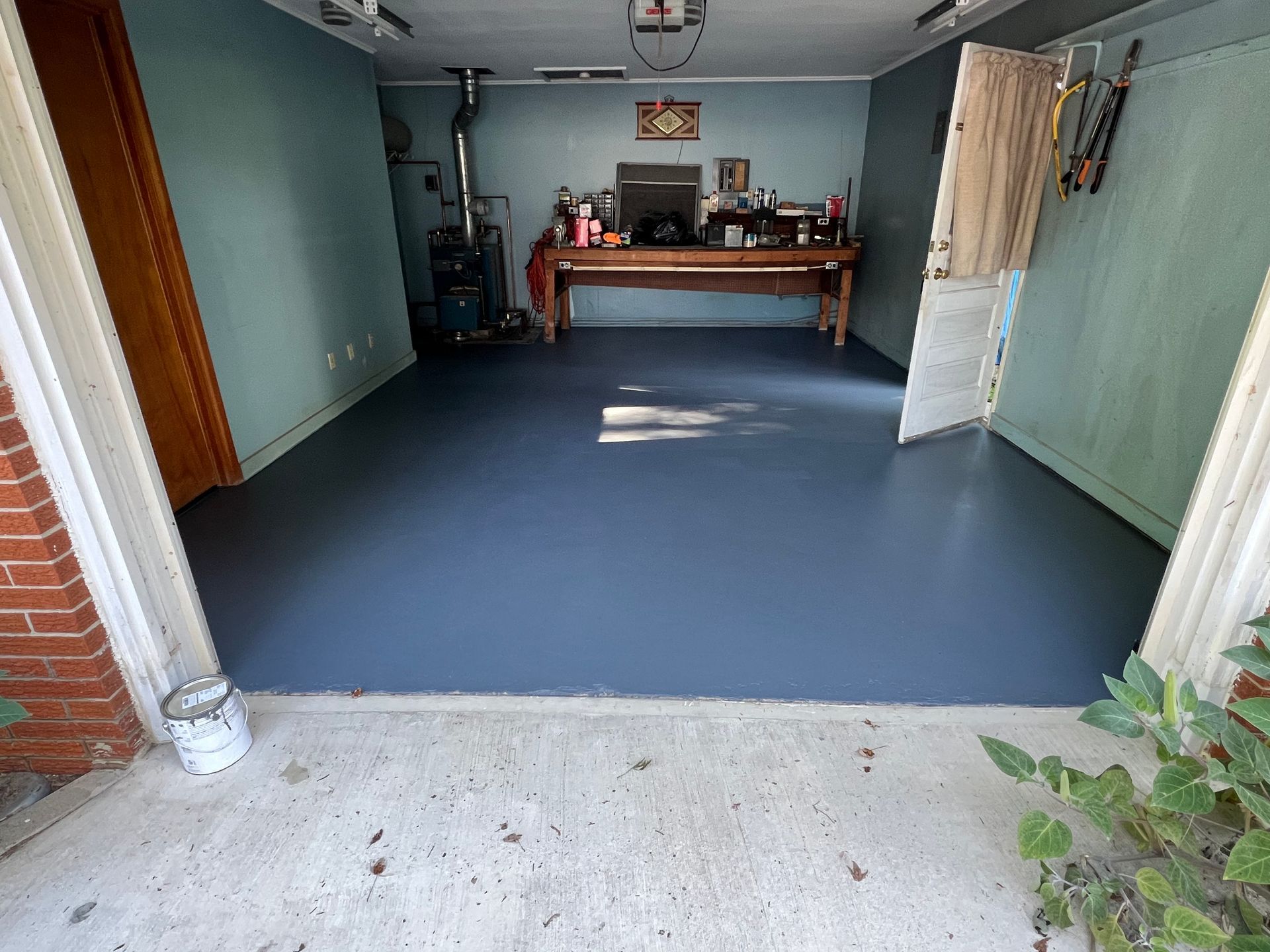 A garage with a blue floor and a wooden table