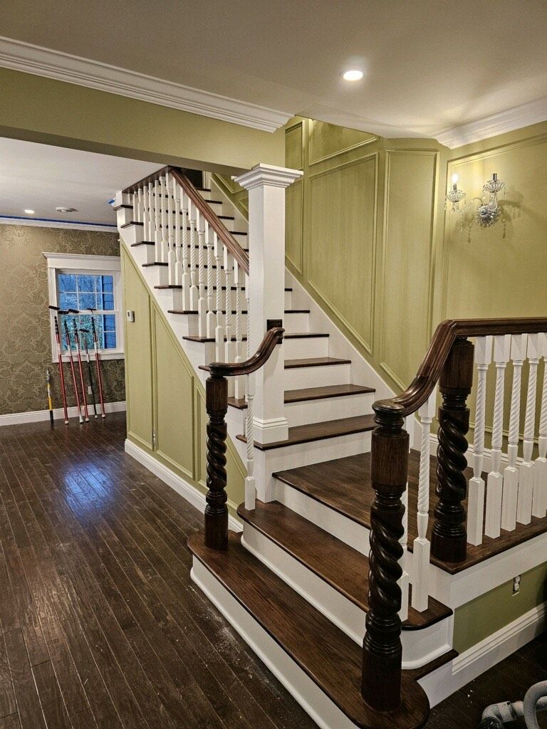 A staircase with wooden steps and white railings in a house.