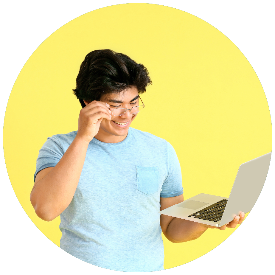 A man wearing glasses is holding a laptop and smiling.