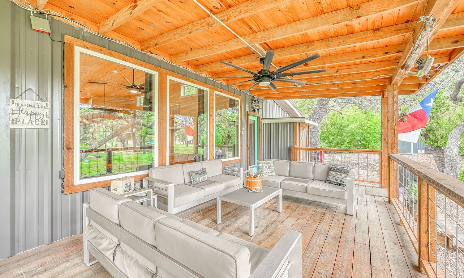 A large porch with a lot of furniture and a ceiling fan.