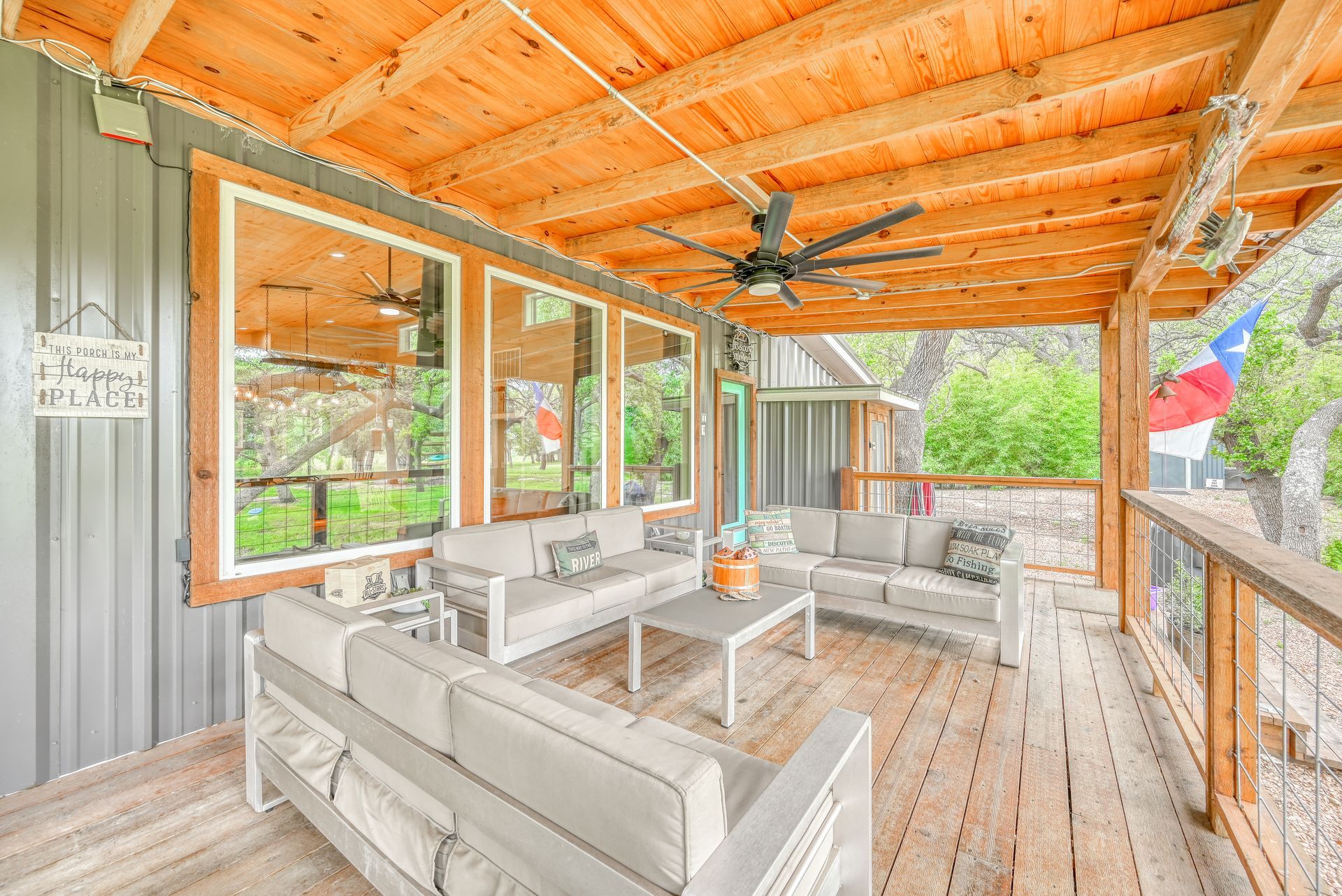 A large porch with a lot of furniture and a ceiling fan.