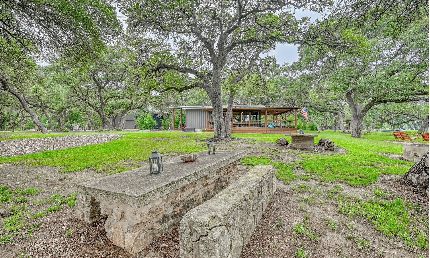 There is a stone picnic table in the middle of a grassy field.