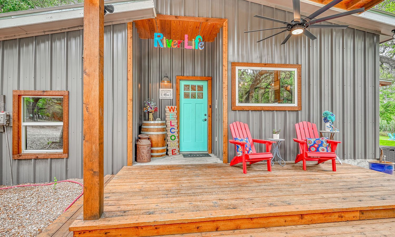 A house with a blue door and red chairs on the porch.