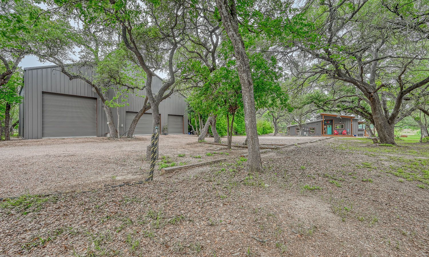A house with a garage and a lot of trees in front of it.