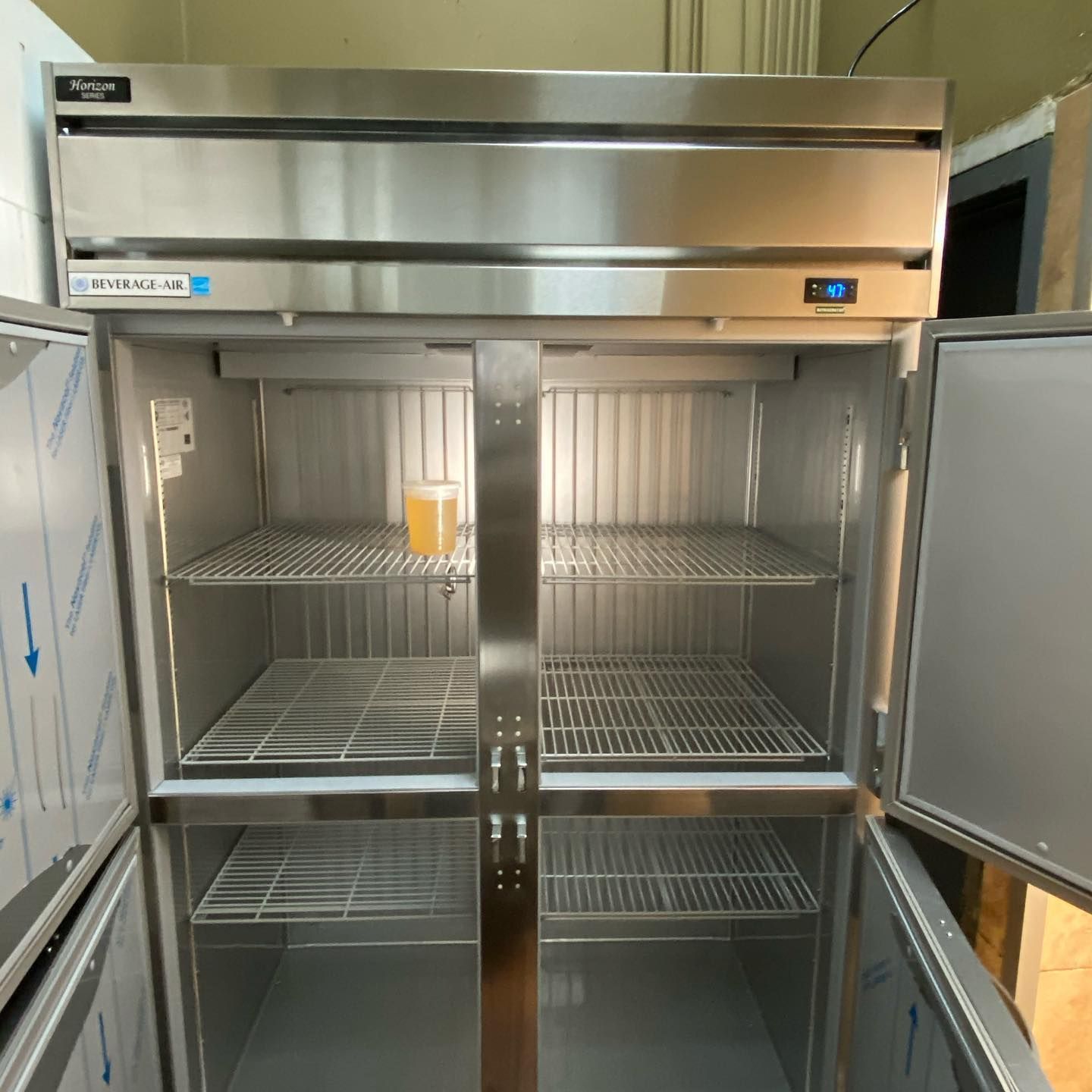 An empty stainless steel refrigerator with the doors open