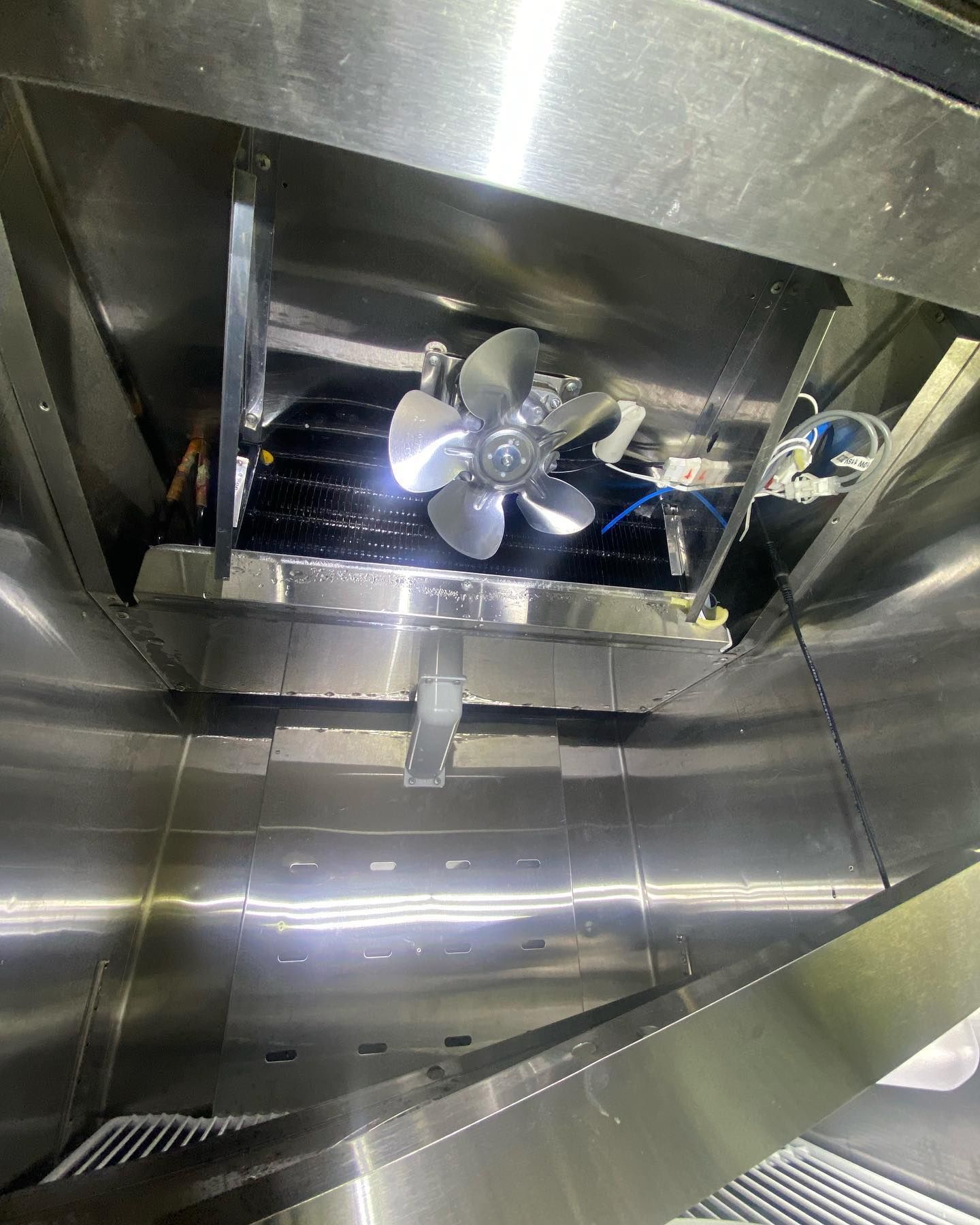 A fan is hanging from the ceiling of a kitchen.