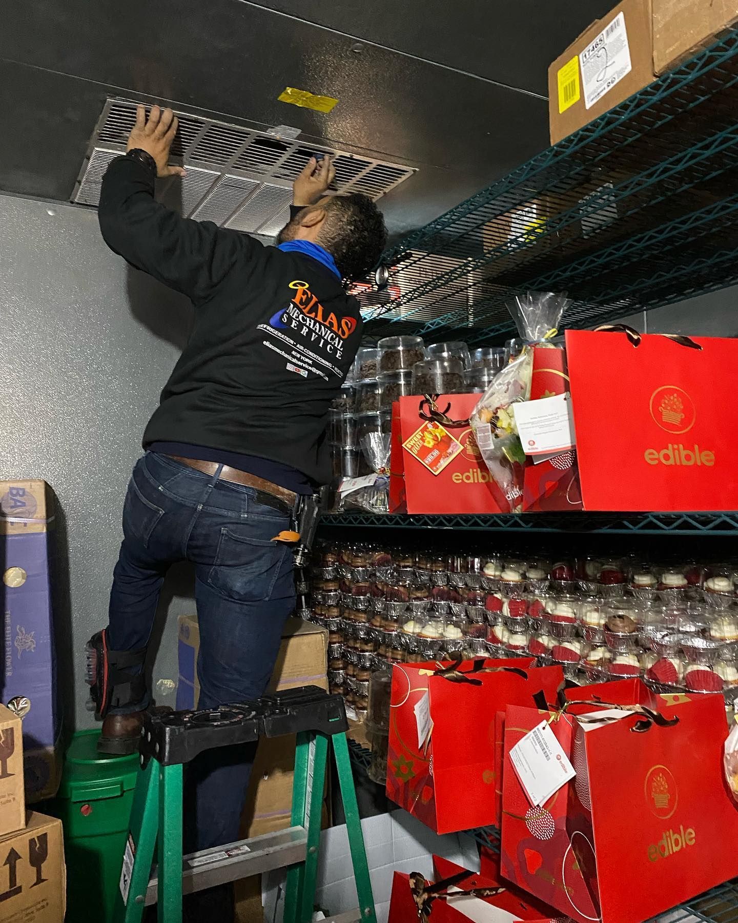 A man is standing on a ladder working on a ceiling.