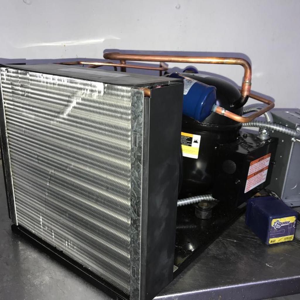 A compressor is sitting on a table next to a radiator