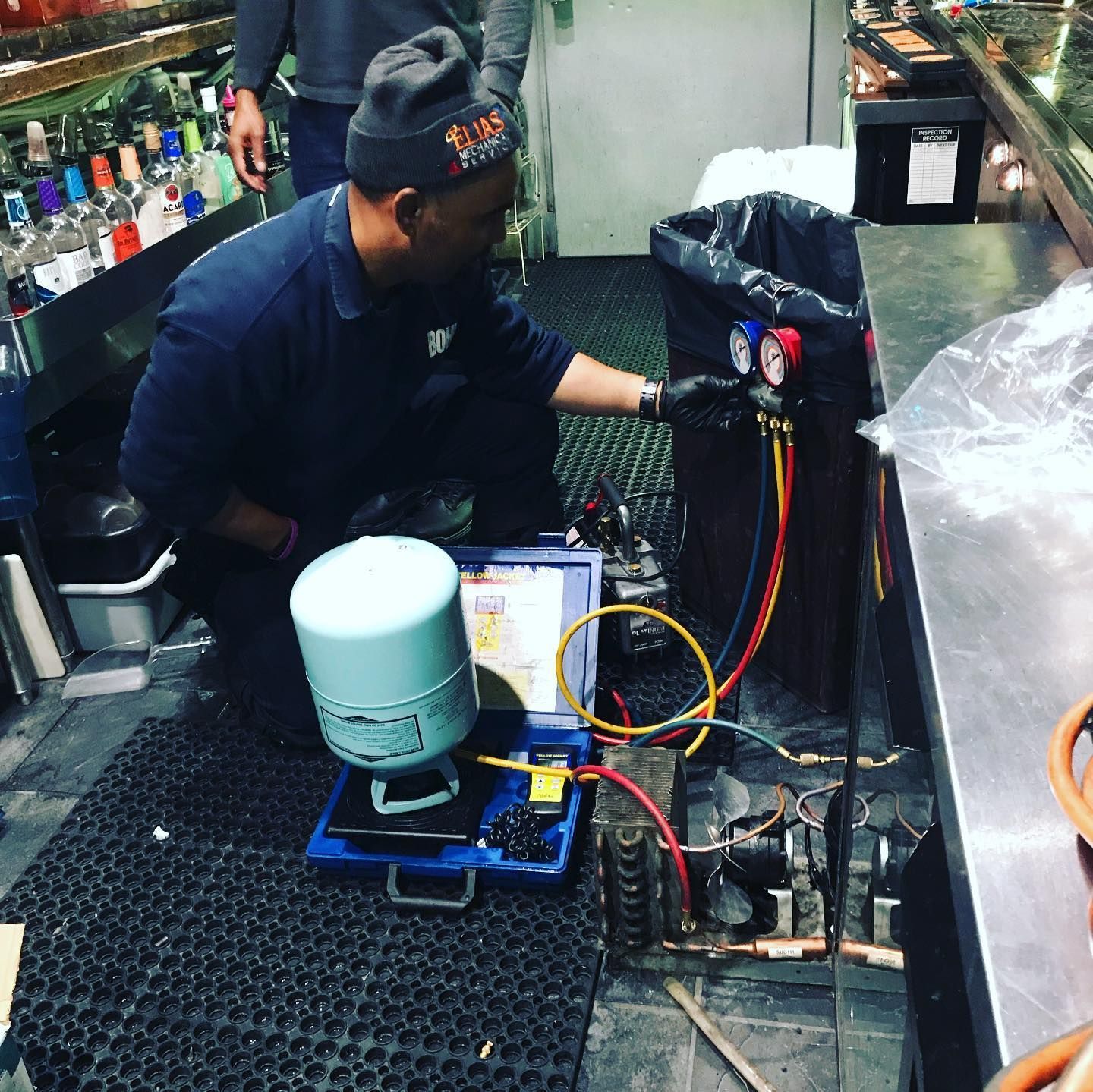 A man is working on an air conditioner in a kitchen