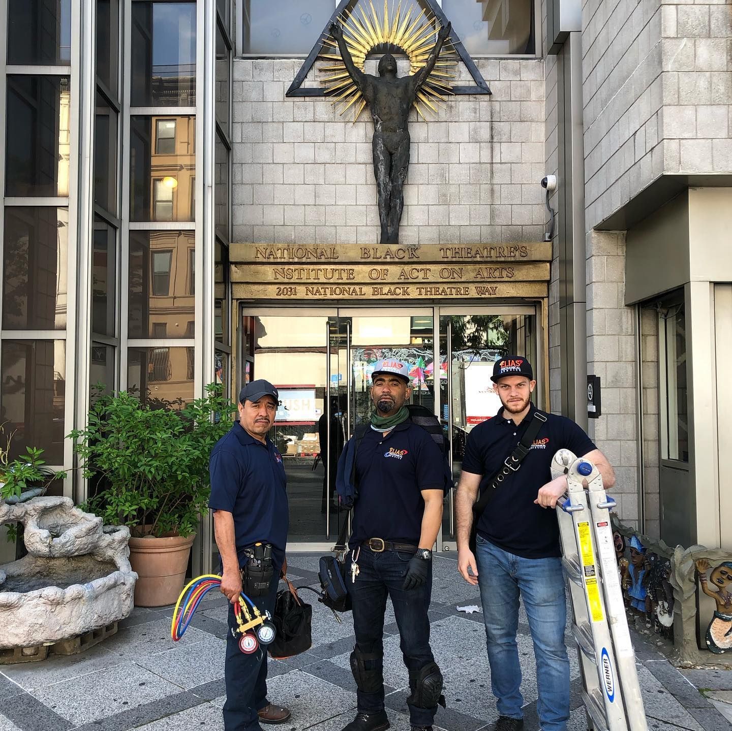 Three men standing in front of a building with a cross on it