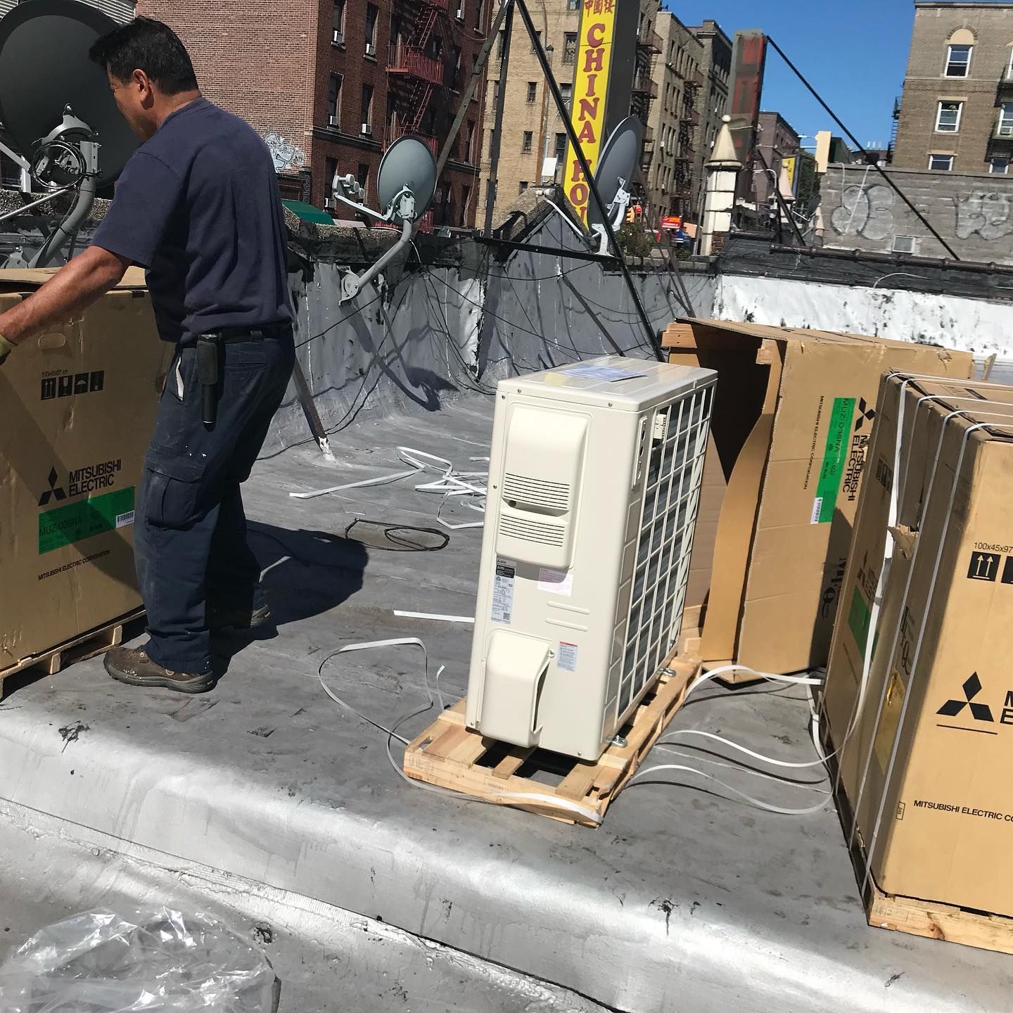 A man is standing next to a box that says ' mitsubishi ' on it