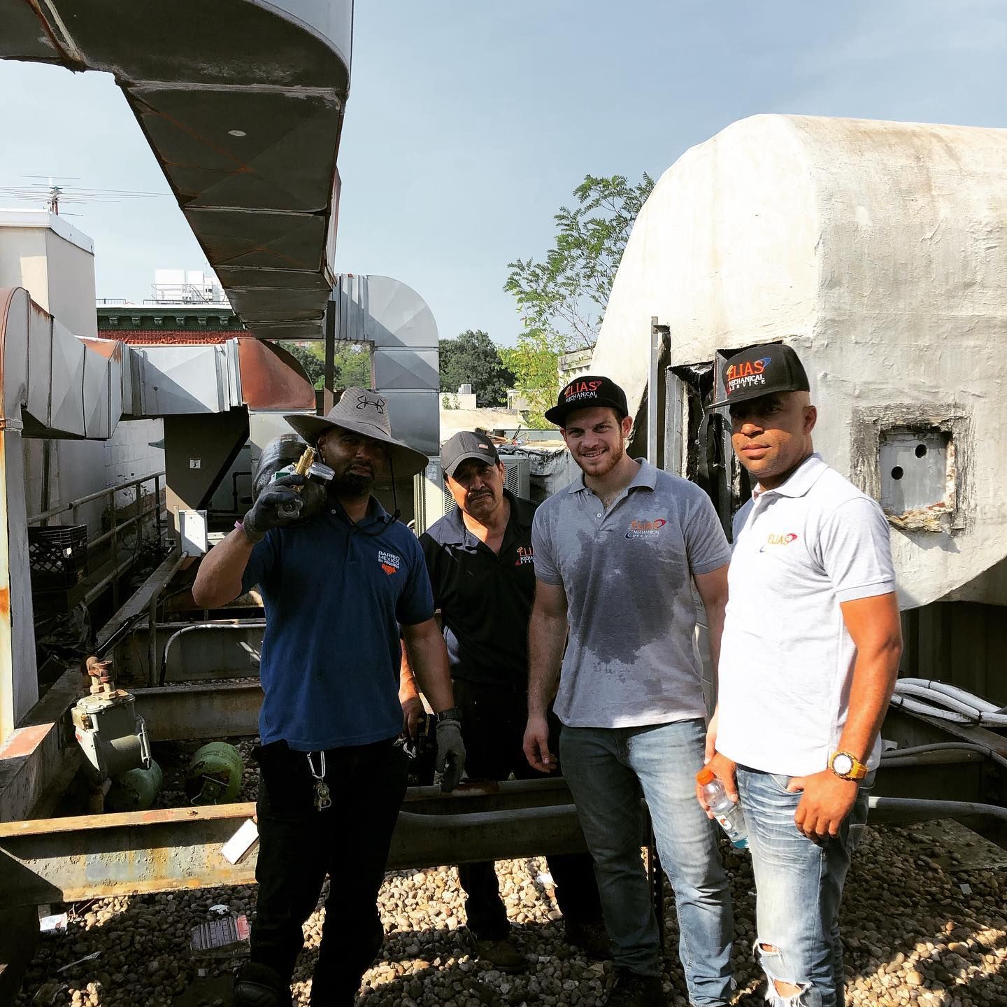 Three men are standing next to each other in front of a building