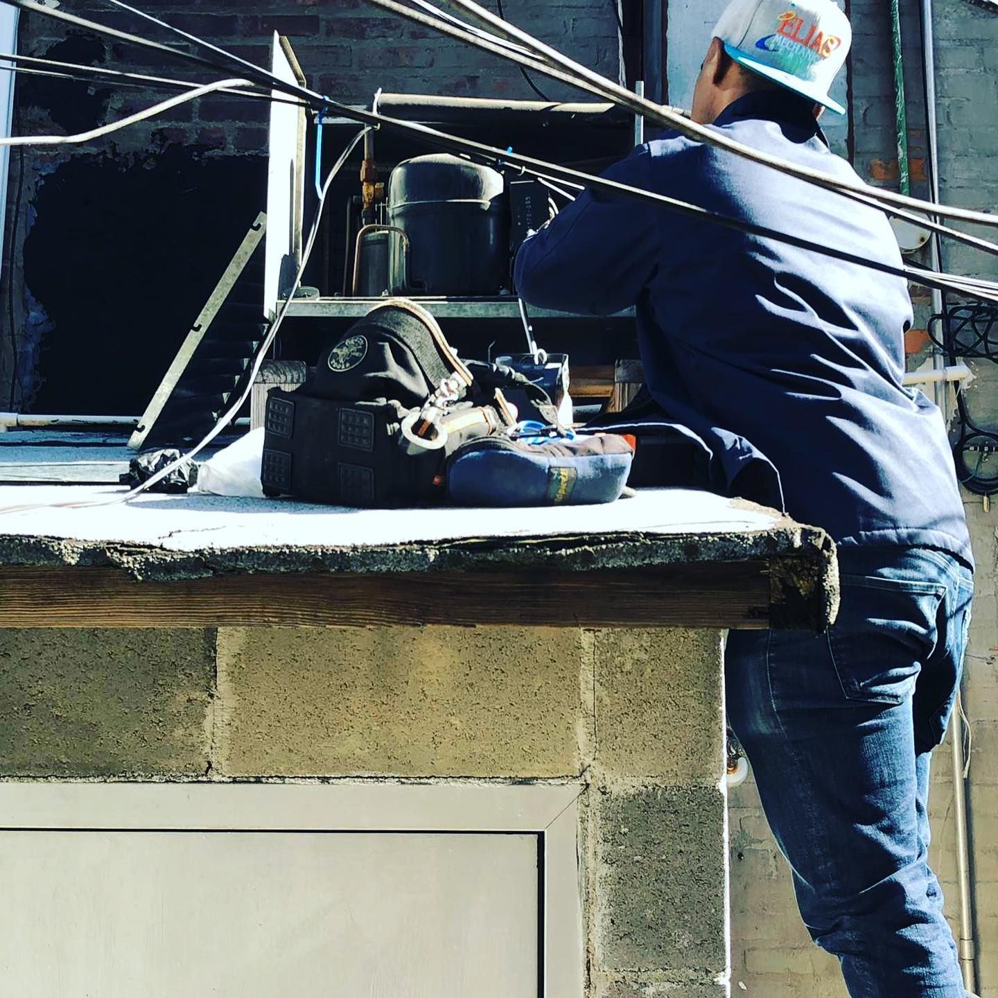 A man wearing a hard hat is working on a roof