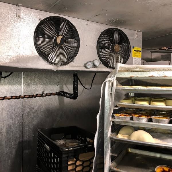 A refrigerator with two fans and a basket of food