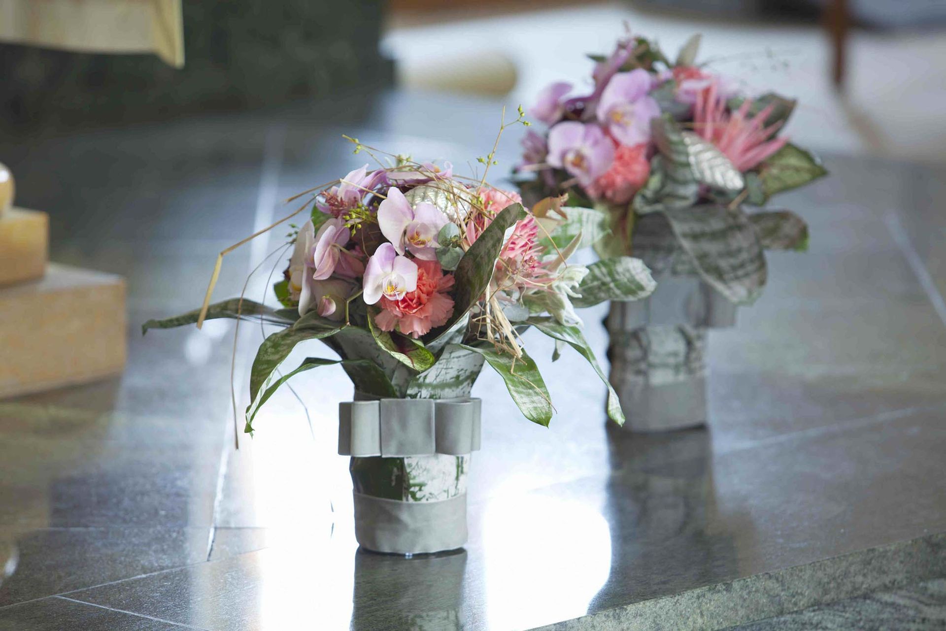 Ein Tisch mit einer Vase mit Blumen und einer Kerze darauf