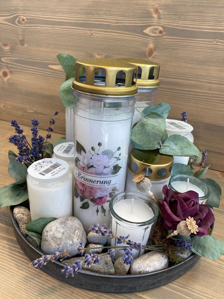 Ein Tablett voller Kerzen und Blumen auf einem Holztisch.