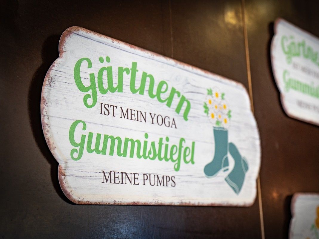 Ein Schild an der Wand mit dem Spruch garten ist mein yoga gummistiefel sind meine Pumps