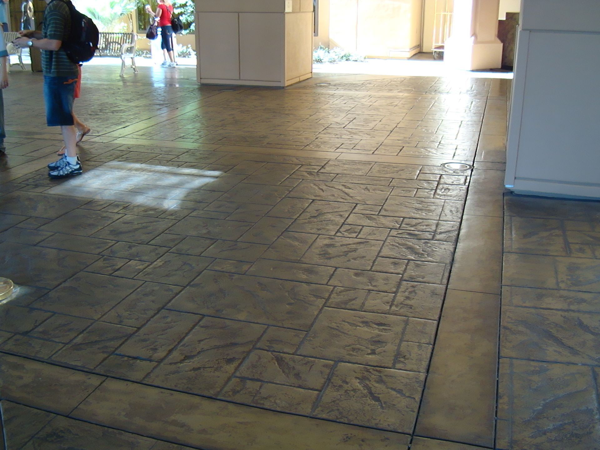 A person walking on a stamped concrete floor in a building