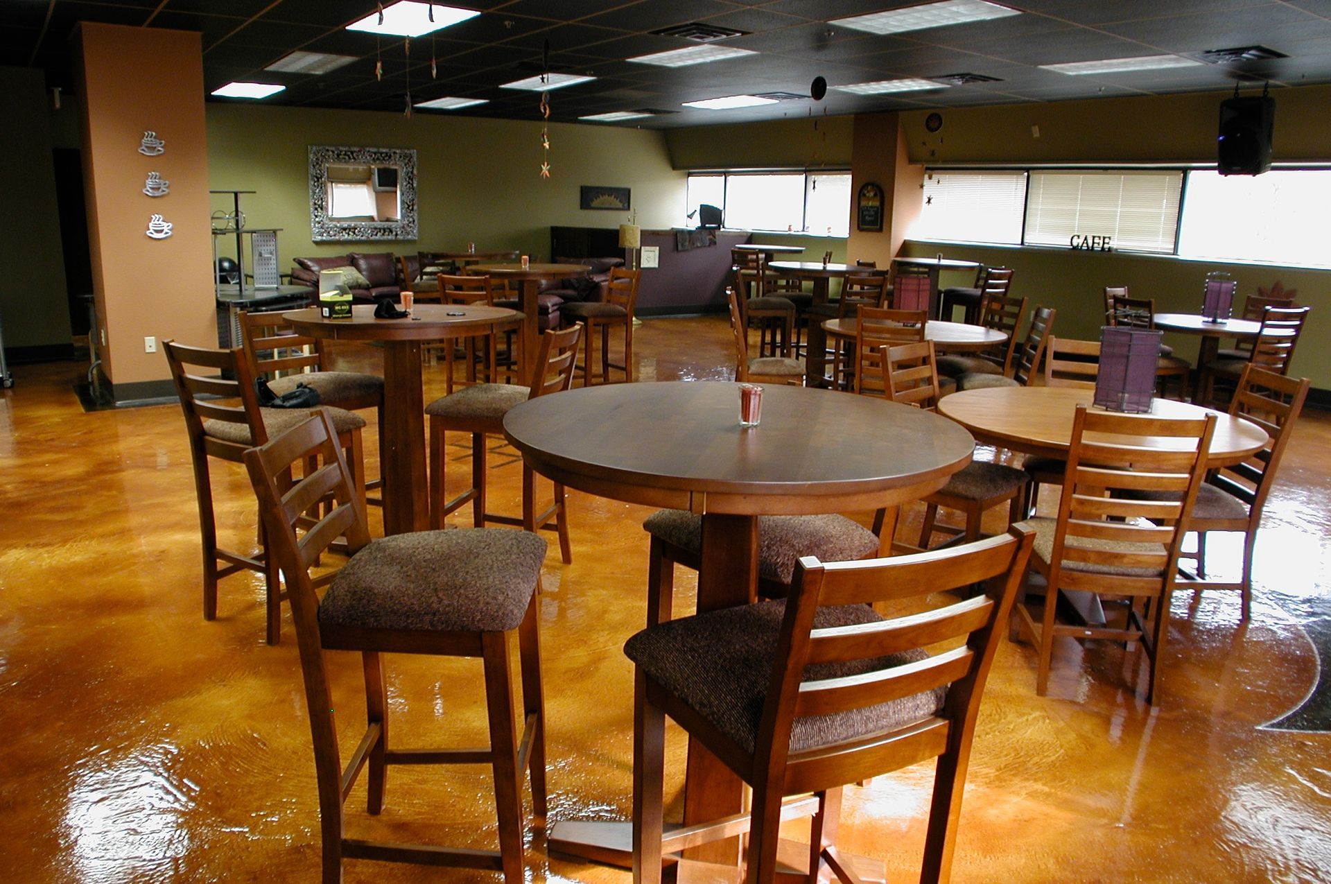 A large room with tables and chairs on a shiny concrete floor