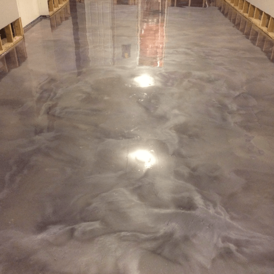 A shiny metallic floor in a room with a lot of shelves.