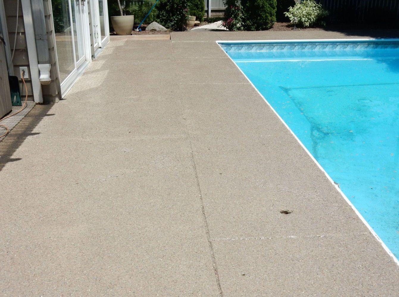 A swimming pool with a concrete deck surrounding it