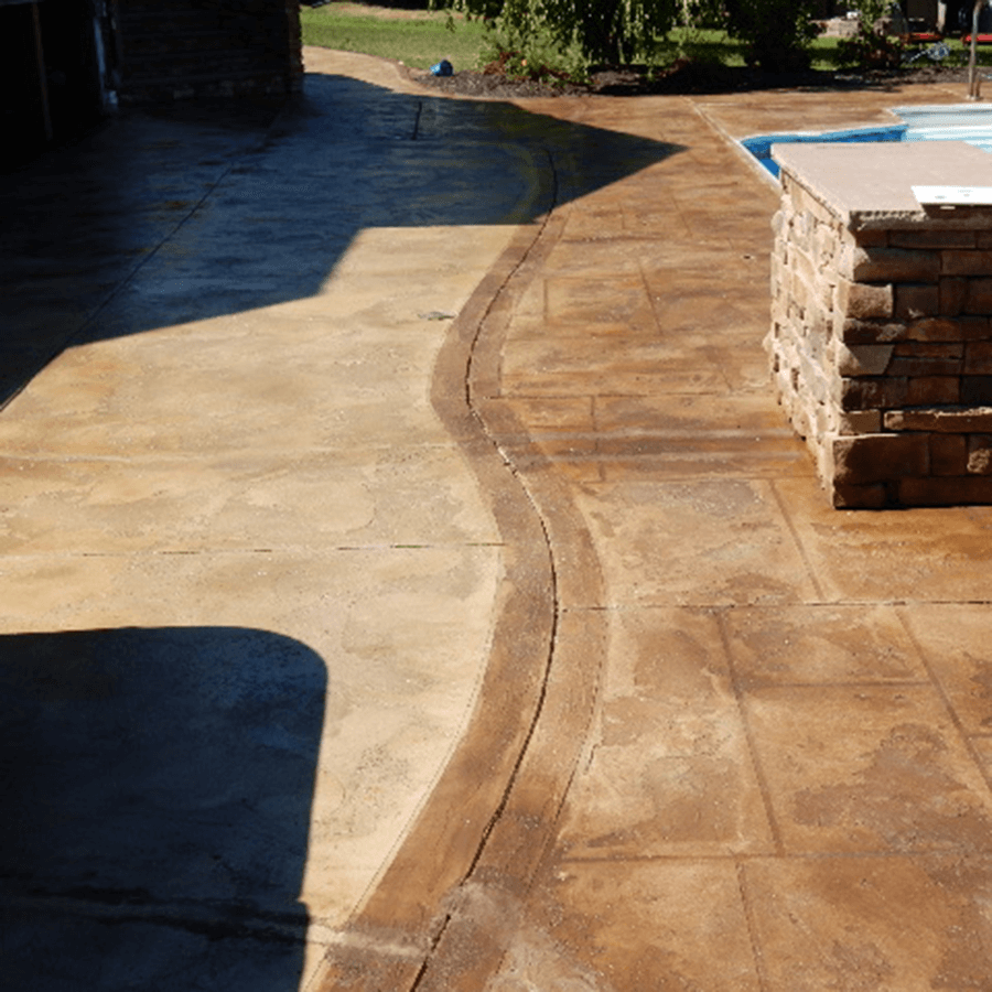 A decorative concrete walkway leading to a swimming pool