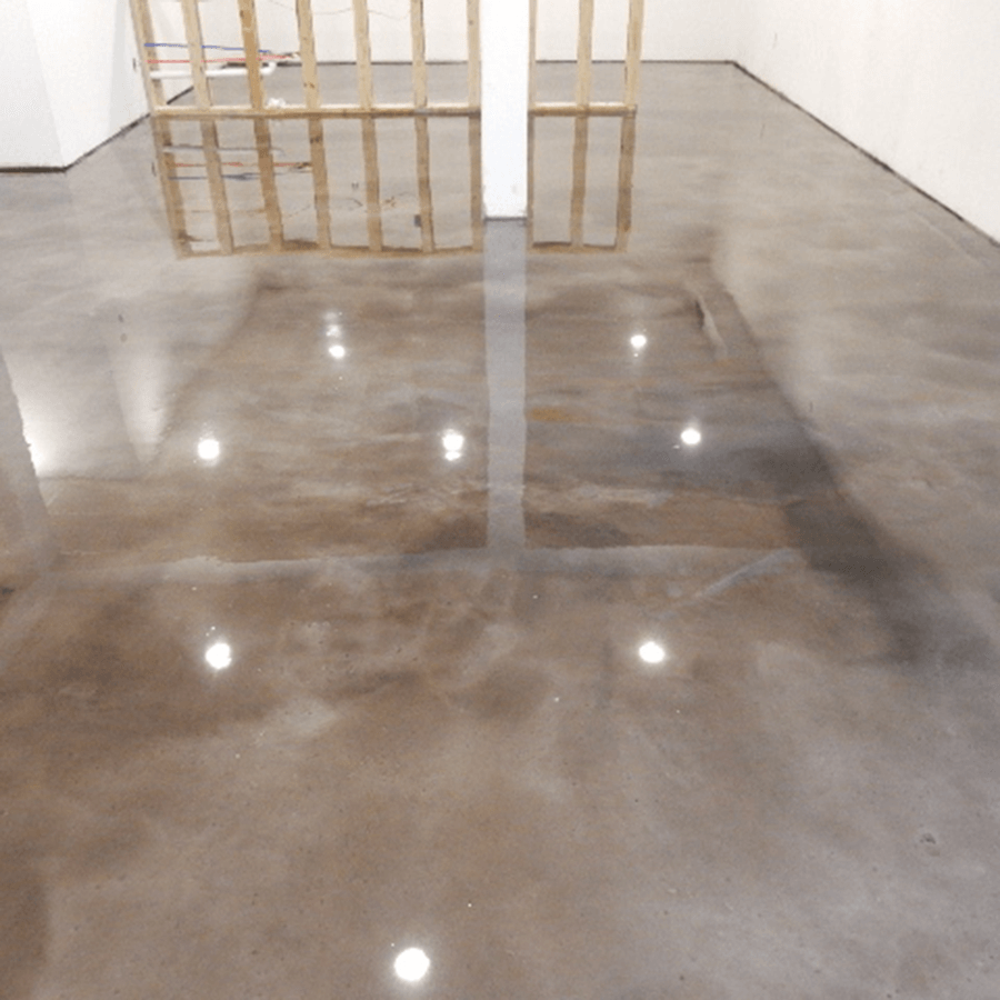 A room with a concrete floor and a wooden fence