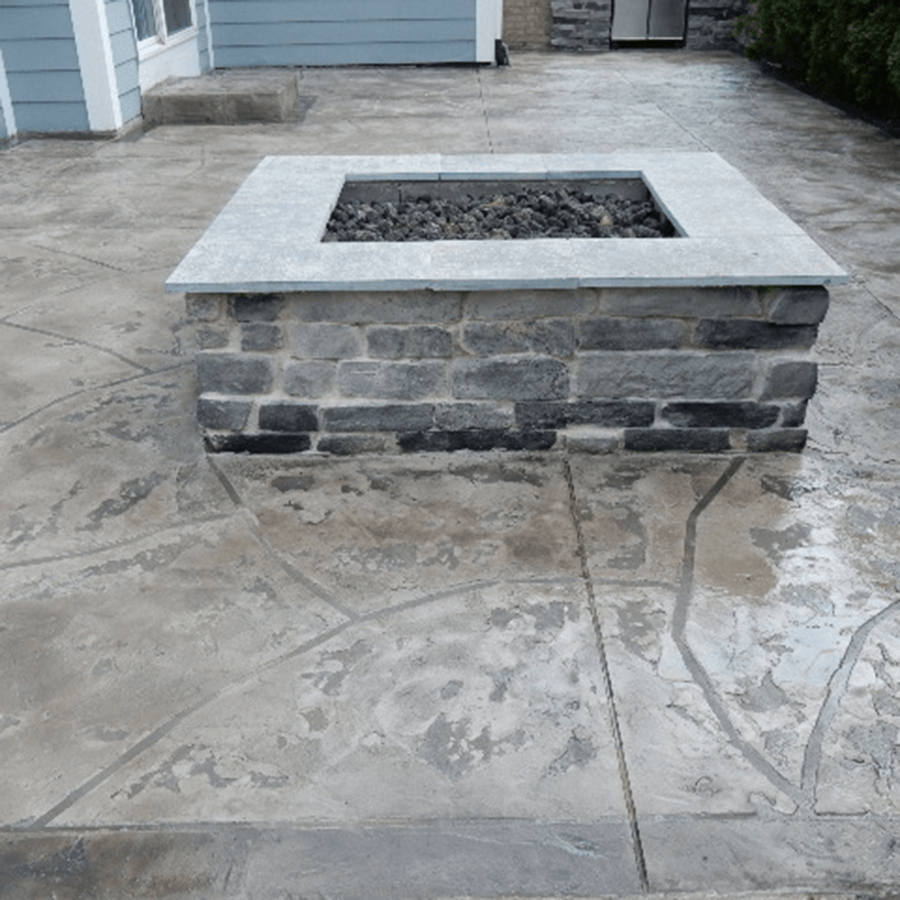 A fire pit in the middle of a stamped concrete patio