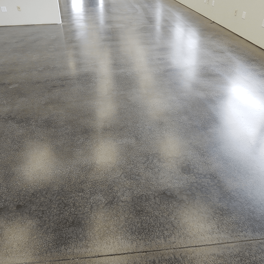 A shiny concrete floor in a room with white walls
