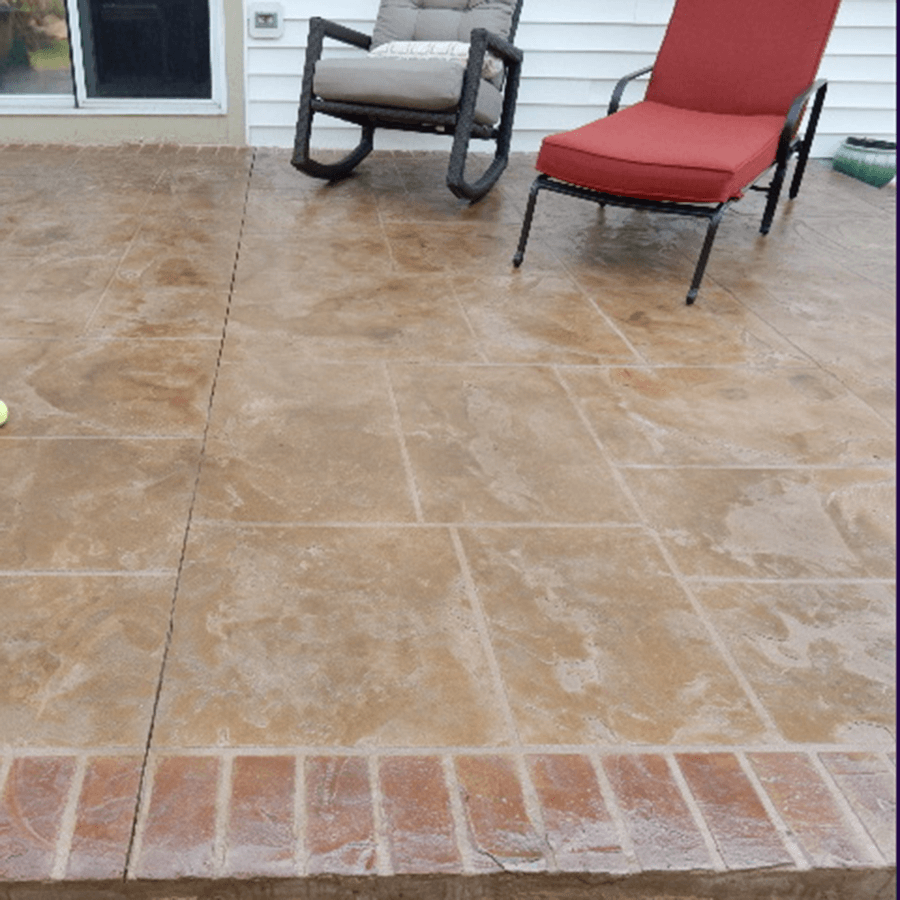 A patio with a rocking chair and a lounge chair on decorative concrete