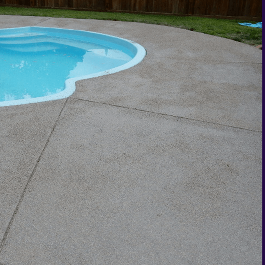 A swimming pool is surrounded by a concrete deck
