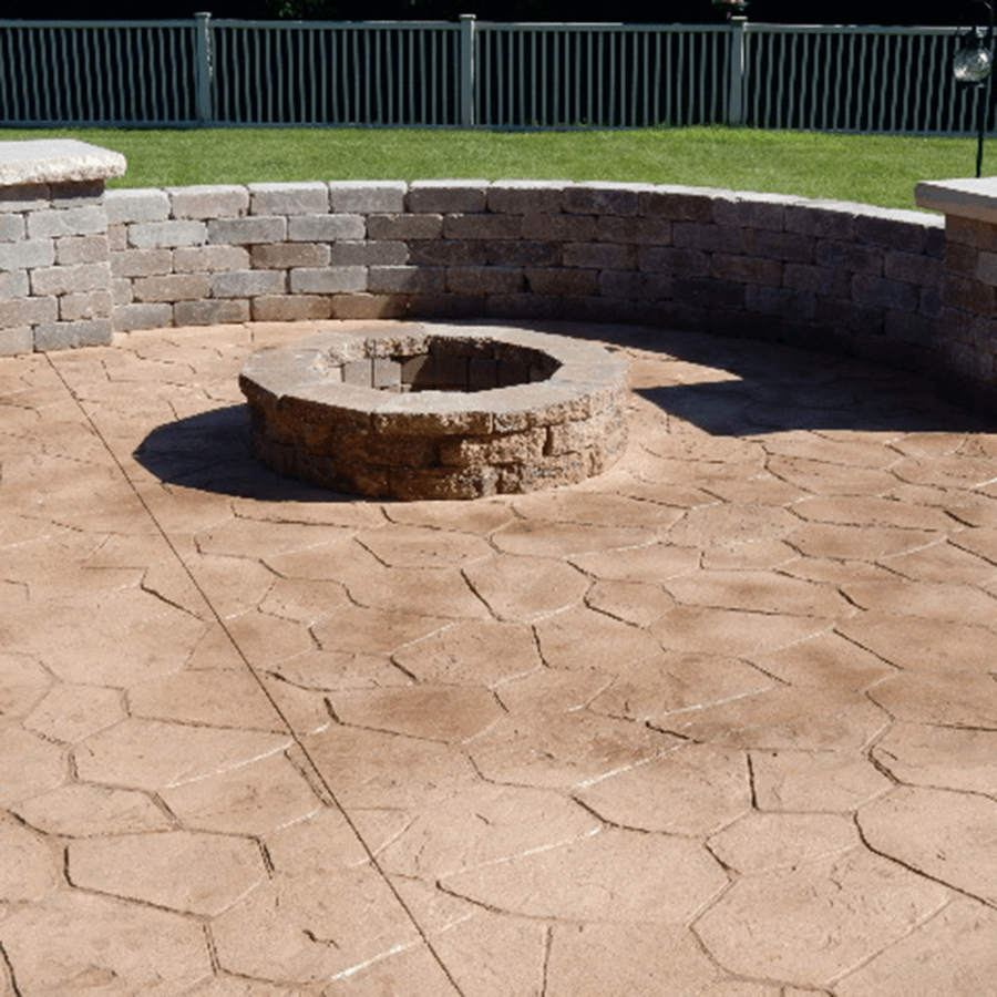 A fire pit sits in the middle of a decorative concrete patio