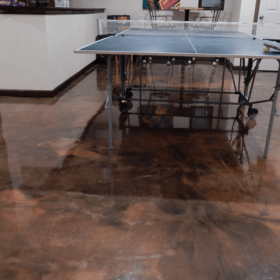 A ping pong table is sitting on a shiny concrete floor in a living room.