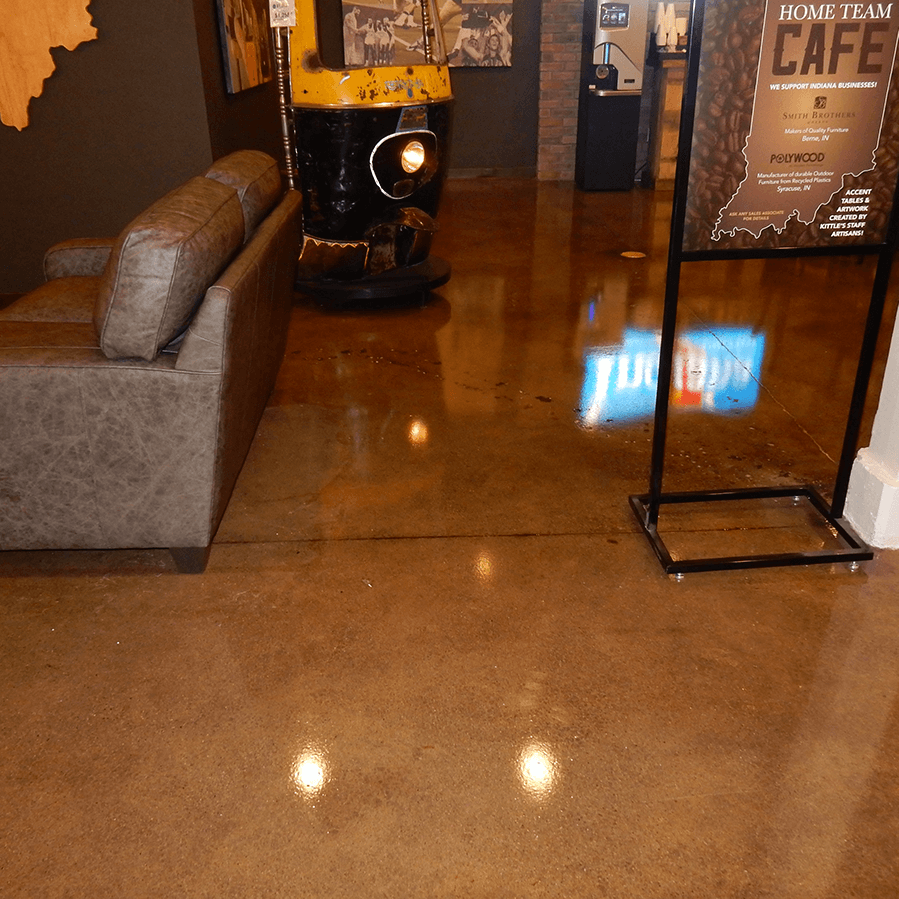 A room with a couch and a sign that says home team cafe on a shiny concrete floor