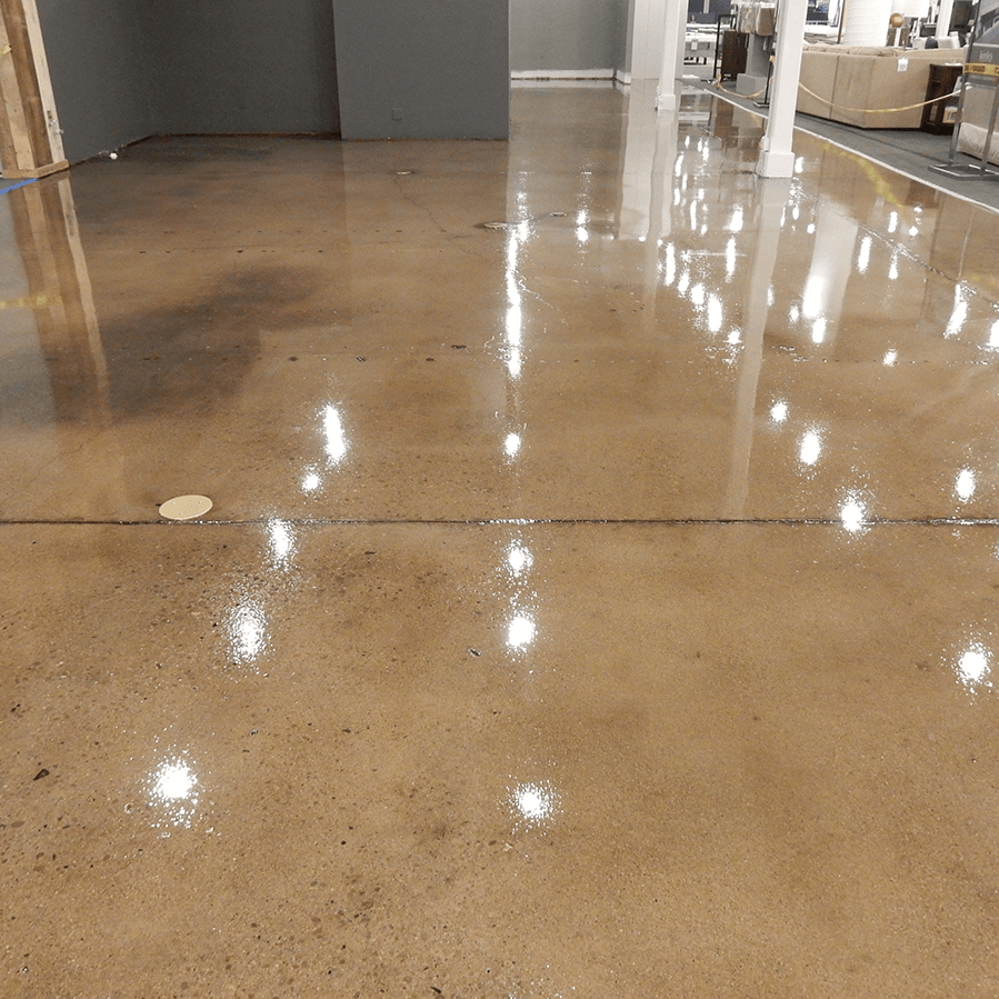 A shiny concrete floor in a room with a lot of lights on it