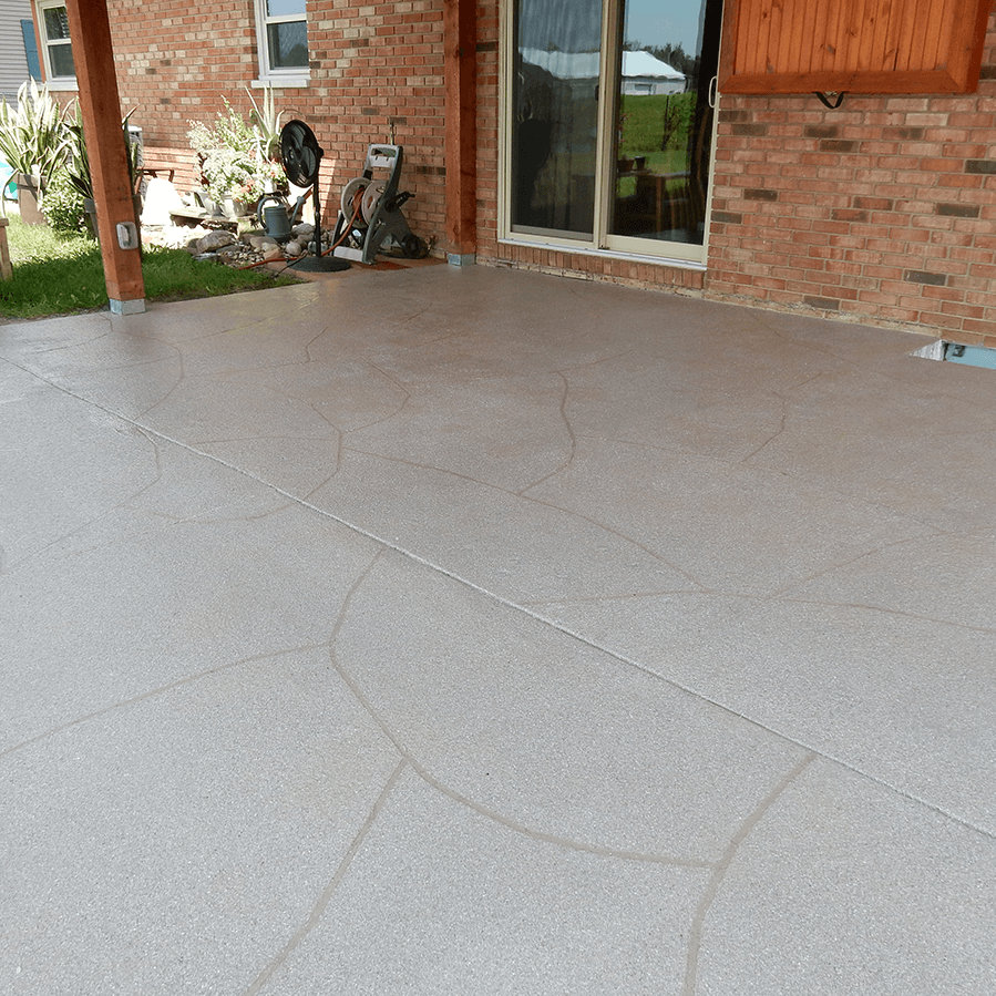 A decorative concrete patio with a sign that says on it