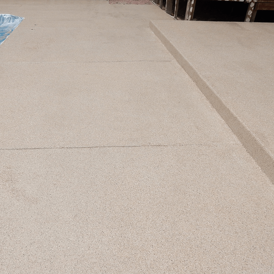 A concrete walkway next to a swimming pool.