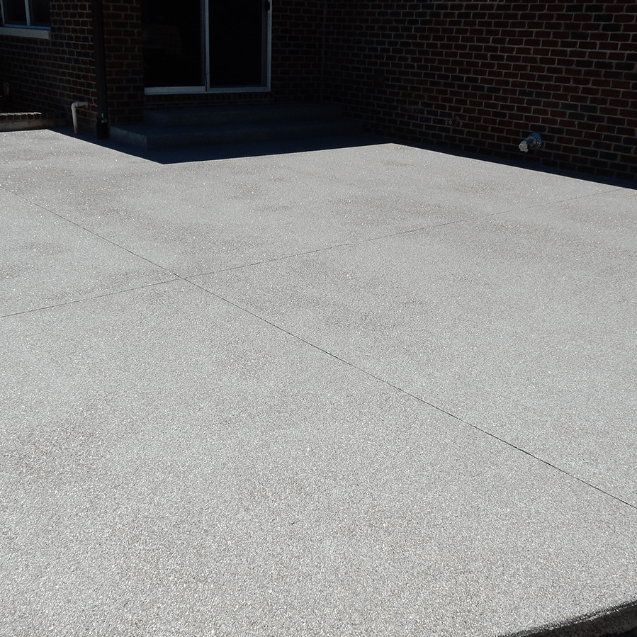 A brick house with a concrete driveway in front of it.