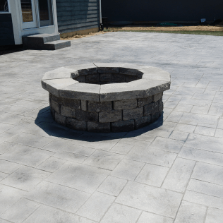 A fire pit made of bricks on a decorative concrete patio