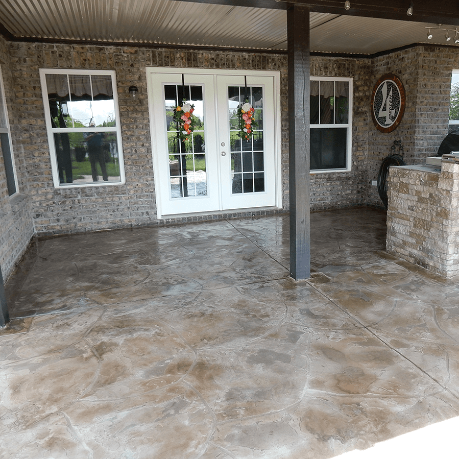 A patio with a brick wall and a decorative concrete floor