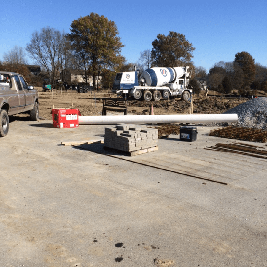 A truck is parked in front of a concrete mixer truck