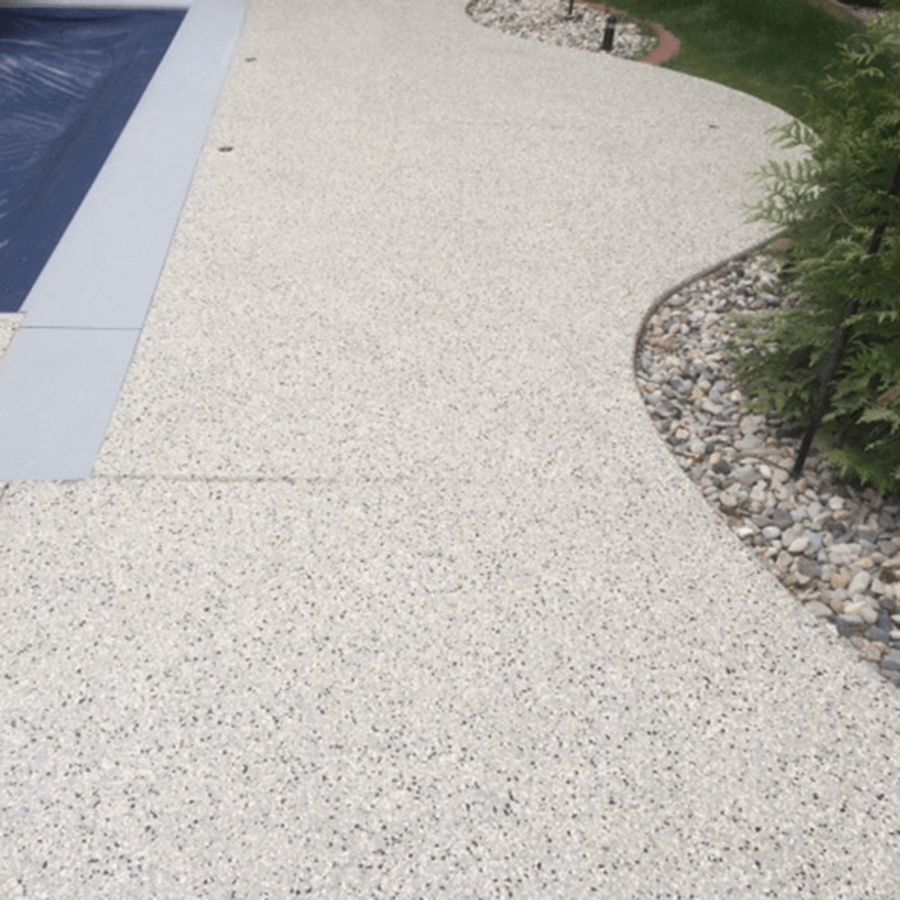 A concrete walkway leading to a swimming pool