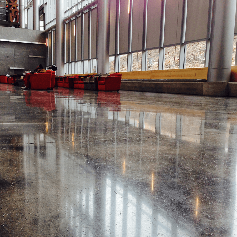 A room with a lot of windows and a shiny concrete floor